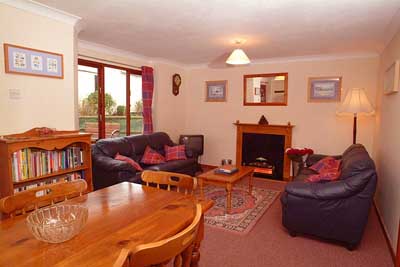 Open plan sitting and dining room area, with archway to fully equipped kitchen with dishwasher